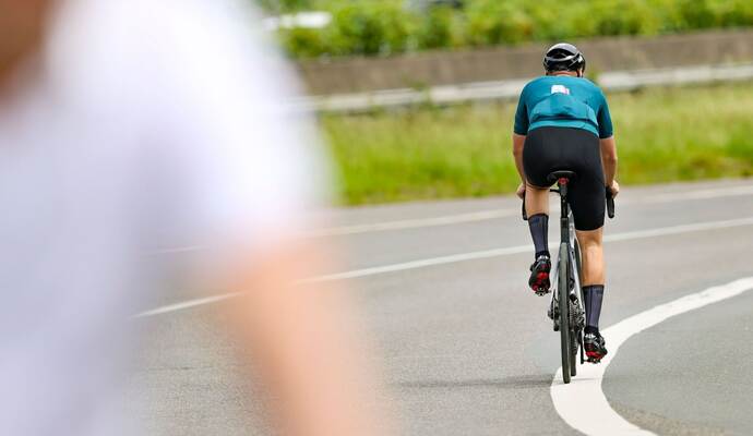 Ein Radfahrer fährt in der Sonne auf seinem Rennrad