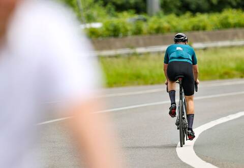 Ein Radfahrer fährt in der Sonne auf seinem Rennrad