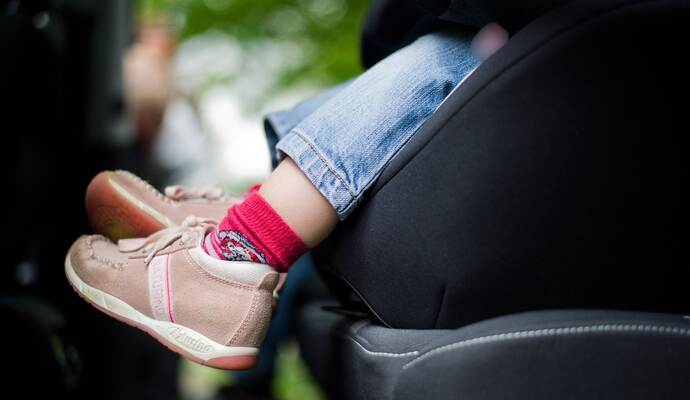 Mädchen sitzt in einem Kindersitz im Auto