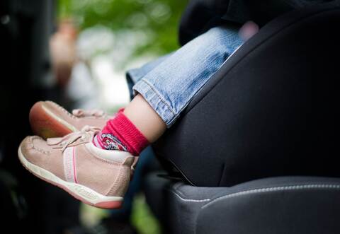 Mädchen sitzt in einem Kindersitz im Auto