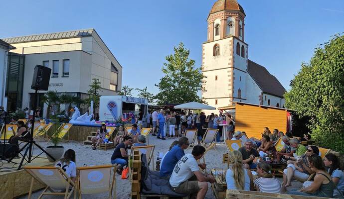 Im Schatten von Rathaus und der Kirche St. Urban und Vitus auf dem Rathausplatz findet ab jetzt jeden Donnerstag bis zum 13. August der Strandsommer statt.