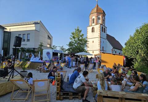 Im Schatten von Rathaus und der Kirche St. Urban und Vitus auf dem Rathausplatz findet ab jetzt jeden Donnerstag bis zum 13. August der Strandsommer statt.