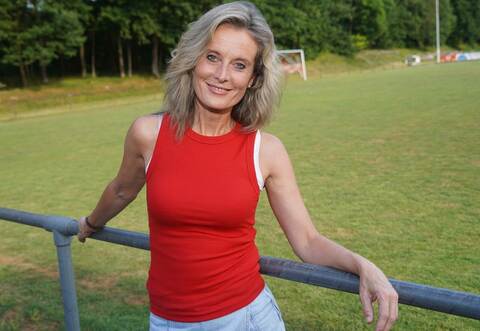 Bianca App steht an der Bande am Sportgelände des FC Nußbaum. Die Sängerin weiß, dass Vereine wie er den Fußball am Leben und die Gesellschaft zusammen halten.