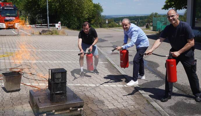 Auch Lehrer Clemens Reiling und Schulleiter Thorsten Metschurat versuchen, einen Brand mit Feuerlöschern zu bekämpfen, unter der Anleitung von Kommandant Martin Irion (von links).