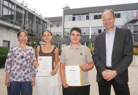 Lehrerin Martina Karsch (links) und Direktor Hartmut Westje-Bachmann (rechts) gratulieren den beiden Preisträgern Jana Schwender und Bennet Hasselberg.