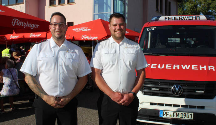 Die Wiernsheimer Abteilungskommandanten Kevin Finke (links) und Chris Weigmann zeigen bei der Feuerwehr-Hocketse den neuen Mannschaftstransportwagen.
