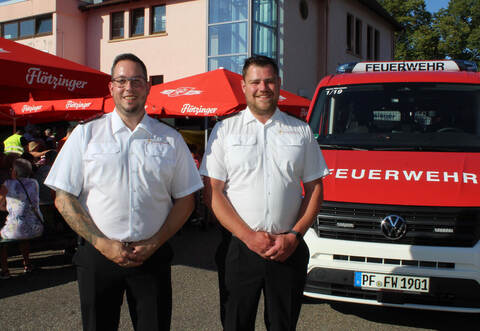 Die Wiernsheimer Abteilungskommandanten Kevin Finke (links) und Chris Weigmann zeigen bei der Feuerwehr-Hocketse den neuen Mannschaftstransportwagen.