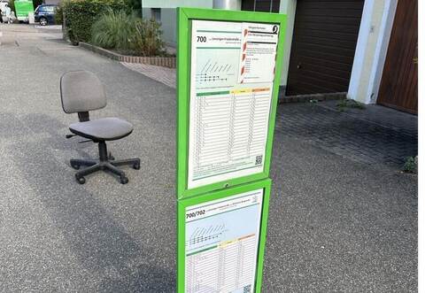 Ein mitfühlender Mensch hat einen Bürostuhl an die Ersatzhaltestelle an der Lienzinger Brühlstraße platziert. Im oberen Info-Kasten ist der Hinweis zum Wochenendeveraltet, wer dem Aushang folgt, wird in die Irre geschickt.