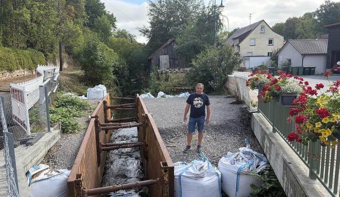 An der Glattbachbrücke zeigt Zeljko Schuhmacher auf das Provisorium, das seit März 2025 den Uferhang sichert. Dem Stadtrat dauert es zu lange, bis die eigentliche Sanierung erfolgt. Rose