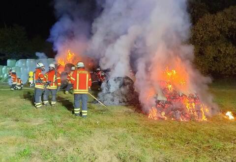 Flammen schlagen am Mittwochabend bei Dietenhausen aus Heu- und Silageballen. Kelterns Feuerwehr löscht stundenlang, aber erfolgreich.