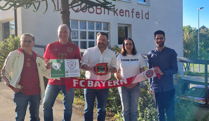 Der Birkenfelder Bürgermeister Martin Steiner in der Mitte und der Vorsitzende des 1. FC Birkenfeld, Elia Cavas (ganz rechts), neben ihm Daniela Widmann, freuen sich über die Defibrillator-Spende des FC Bayern Fanclubs Birkenfeld um die Vorsitzenden Andrew Hashimoto (von links) und Achim Bach.