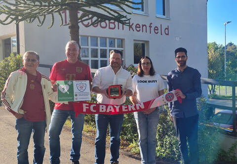 Der Birkenfelder Bürgermeister Martin Steiner in der Mitte und der Vorsitzende des 1. FC Birkenfeld, Elia Cavas (ganz rechts), neben ihm Daniela Widmann, freuen sich über die Defibrillator-Spende des FC Bayern Fanclubs Birkenfeld um die Vorsitzenden Andrew Hashimoto (von links) und Achim Bach.
