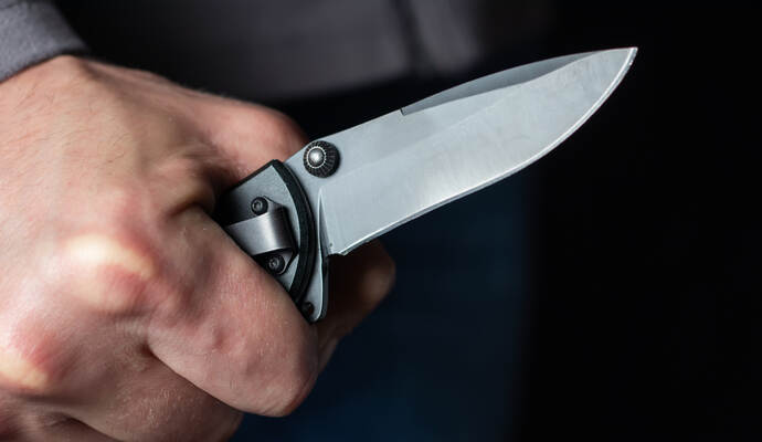 Man holding a knife in a threatening stance ready to fight