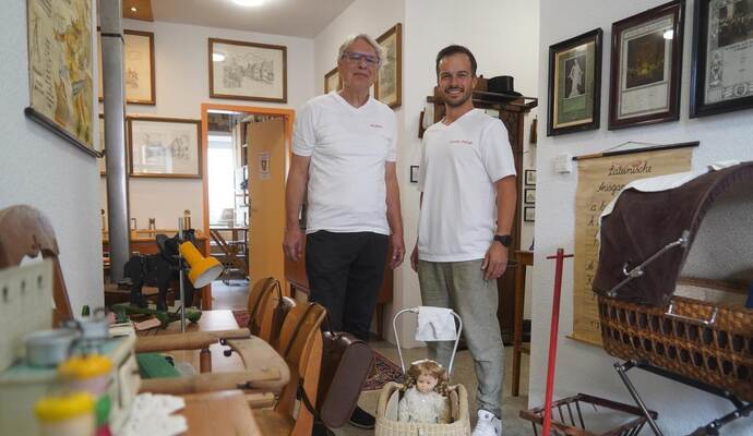 Museums-Initiator Andreas Überschaer (links) und Bürgermeister Sascha-Felipe Hottinger stehen in einem Raum des neuen Heimatmuseums, der sich der Kindheit und der Schulzeit widmet.