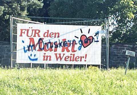 Pro und kontra Supermarkt auf einem Banner. Mit dem Übermalen möchte die Bürgerinitiative „Hofacker Weiler“ allerdings nichts zu tun haben. Sie wehrt sich eigenen Worten zufolge gegen falsche Verdächtigungen und stellt Anzeige.