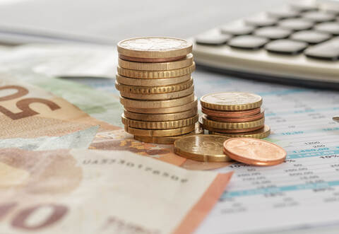 Geld mit Taschenrechner und Kugelschreiber