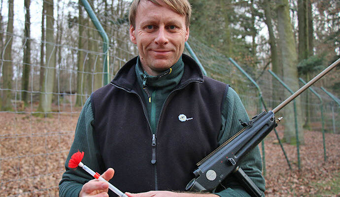 Wildpark-Förster Carsten Schwarz mit seinem Betäubungsgewehr und einem Narkosepfeil. Foto: Hauser