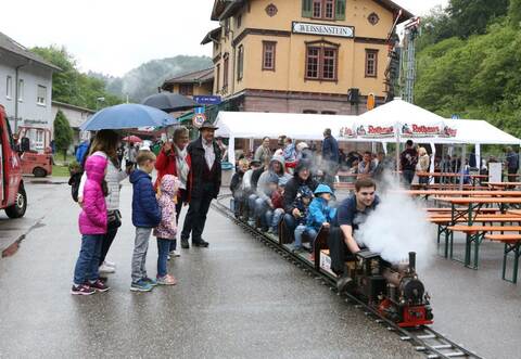 Trotz des Regens lassen die Pforzheimer Eisenbahnfreunde ihr Dampfbähnle vor dem Weißensteiner Bahnhof beim Vatertagsfest unter Volldampf fahren. Und nicht nur die Kleinsten haben ihre Freude daran.