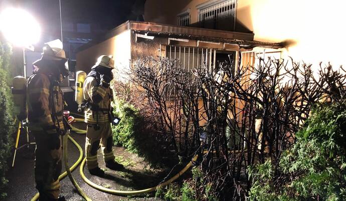 Die herbeigeeilte Feuerwehr löschte das Feuer an der Hecke.
