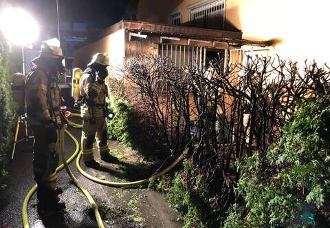 Die herbeigeeilte Feuerwehr löschte das Feuer an der Hecke.