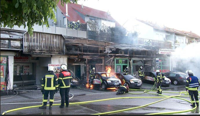 Als die Feuerwehr eintraf, standen die komplette Ladenzeile sowie mehrere Fahrzeuge in Flammen. Als die Feuerwehr eintraf, standen die komplette Ladenzeile sowie mehrere Fahrzeuge in Flammen.