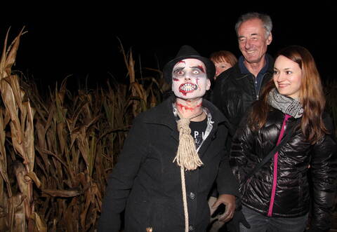 Einfach zum Fürchten: Ute und Arthur Peuker aus Arnbach wagten sich mit ihrer Schwiegertochter Ann-Christin Heim (rechts) in das nur teils beleuchtete Maislabyrinth und wurden unterwegs von verkleideten Gestalten wie diesem „Zombie mit Galgenstrick“ überrascht.