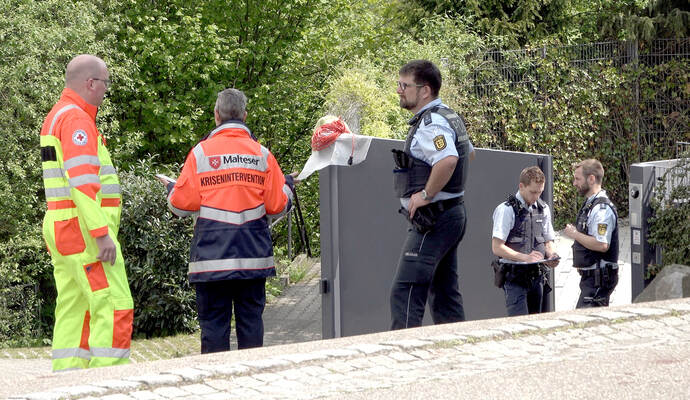 Polizisten, ein Mitarbeiter des Roten Kreuzes und ein Mitglied des Kriseninterventionsteams der Malteser stehen in der Einfahrt zu einem Wohnhaus. Ein Familienvater steht im Verdacht, seine Frau und einen Sohn getötet zu haben.
