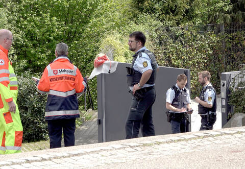 Polizisten, ein Mitarbeiter des Roten Kreuzes und ein Mitglied des Kriseninterventionsteams der Malteser stehen in der Einfahrt zu einem Wohnhaus. Ein Familienvater steht im Verdacht, seine Frau und einen Sohn getötet zu haben.