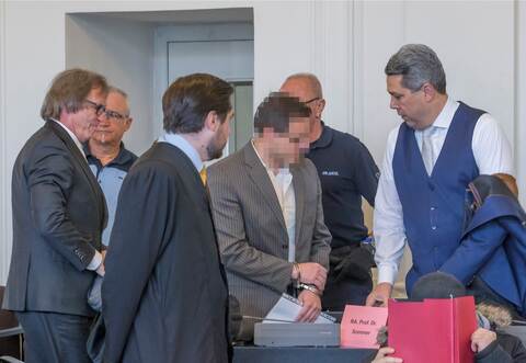 Vor dem Landgericht in Karlsruhe ist der Mordprozess im Fall Paulus fortgesetzt worden. Im Bild unter anderem zu sehen: der Hauptangeklagte (Gesicht gepixelt) mit seinen beiden Verteidigern, Professor Ulrich Sommer aus Köln (ganz links) und Cornelius Schaffrath aus Pforzheim (ganz rechts).