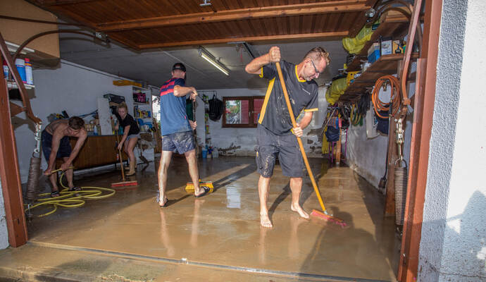 Raus mit der Brühe: Familie Diebold kämpft mit Helfern an der Dreisamstraße gegen die Überschwemmung. Vorne von links: Raphael Diebold und Michael Drapa.