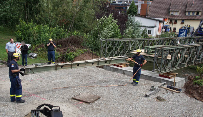 Stück für Stück bauen ehrenamtliche Helfer des THW die Brücke zusammen.