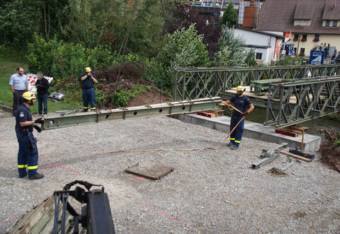 Stück für Stück bauen ehrenamtliche Helfer des THW die Brücke zusammen.