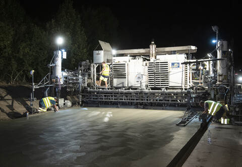 Betonfertiger: diese 14-Meter-Maschine betoniert die Fahrbahn rund um die Uhr mit einem Meter pro Minute. Es entsteht ein besonders haltbarer Straßenbelag, der bei hohem Schwerverkehrsanteil sehr beständig ist.