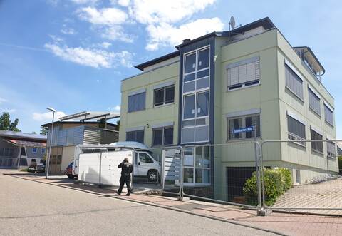 Das Gebäude in Engelsbrand ist eingezäunt, ein Security-Mitarbeiter überwacht das Geschehen.