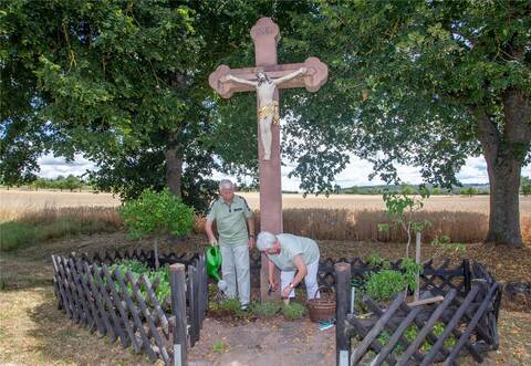 Das Feldkreuz in Mühlhausen wird von Petronilla und Adolf Friedl gepflegt. Mit Kanne, Schere und Hacke sind sie regelmäßig im Einsatz. Foto: Meyer