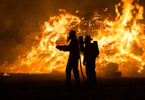 Die Feuerwehr kämpfte gegen die Flammen, die von einem Holzstapel ausgingen.