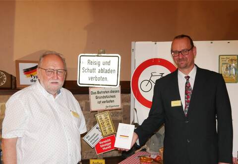 Hermann Kölbel (links), ehemaliger Pastor der Süddeutschen Gemeinschaft, Maulbronner Bürger und wichtiger Unterstützer des Projekts, und Ausstellungsbegründer Tim Behrensmeier präsentieren das zentrale Werk der Ausstellung. Zum Abschluss einer jeden Führung erhalten die Teilnehmer auf Wunsch eine Ausgabe des Grundgesetzes.