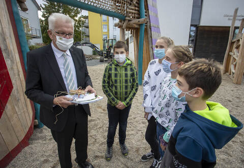 Nikolas, Lucie, Jana und Jonas (von rechts) haben Ministerpräsident Winfried Kretschmann ein Geschenk der Gemeinde Remchingen mitgebracht.
