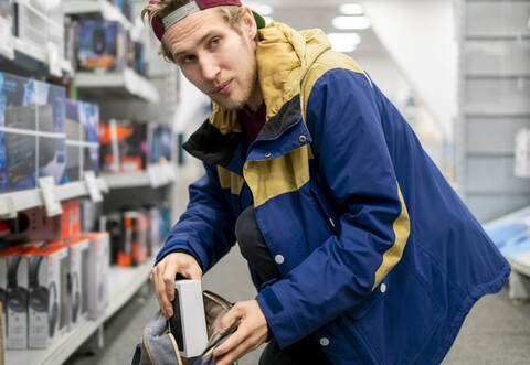 shoplifter in the electronic store supermarket stealing new gadget