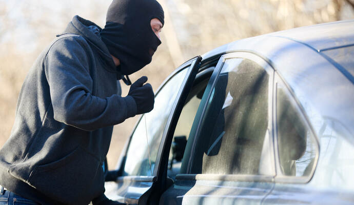 Thief stealing automobile car at daylight street in city