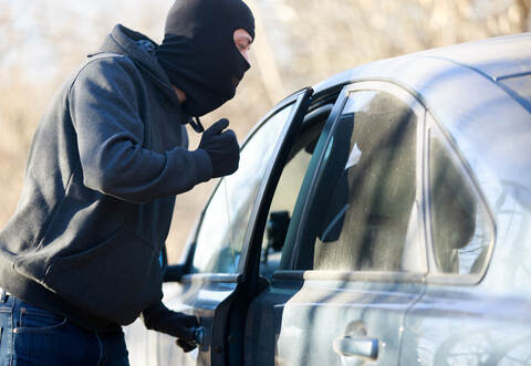 Thief stealing automobile car at daylight street in city