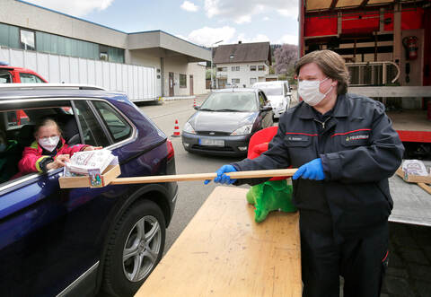 Freude an der Stange: Bei der Osteraktion der Freiwilligen Feuerwehr und der Gemeinde Niefern-Öschelbronn überreicht hier beim eigens eingerichteten Drive-In am Feuerwehrhaus in Niefern Sarah Koppe der achtjährigen Josephine Sadler aus Niefern ein Osterpaket. Foto: Tilo Kell