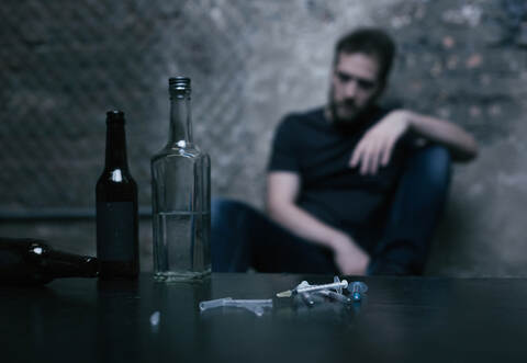 Alcohol in bottles and used syringes lying on the table
