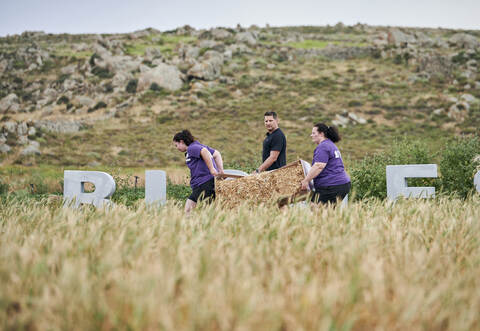 Insgesamt 600 Kilogramm Strohballen müssen Birgit (rechts) und Fabienne schleppen. Trainer Ramin Abtin feuert die beiden an.