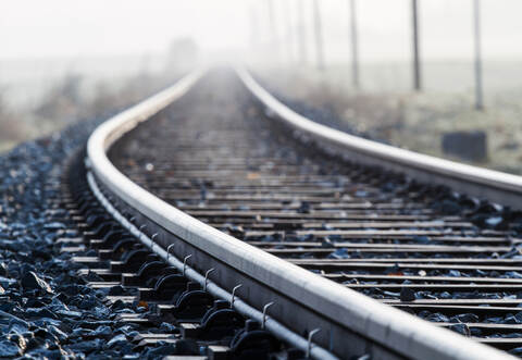 Einspurige Bahnlinie im Morgennebel