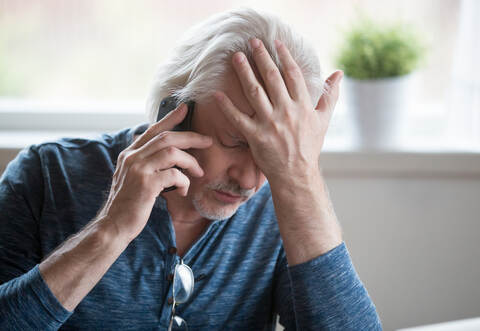 Frustrated mature man feeling upset desperate talking on the pho