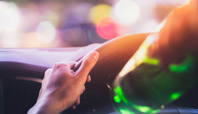 Drinking and driving ,man drinking alcohol while driving car after party at night time