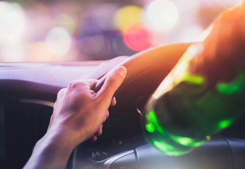 Drinking and driving ,man drinking alcohol while driving car after party at night time