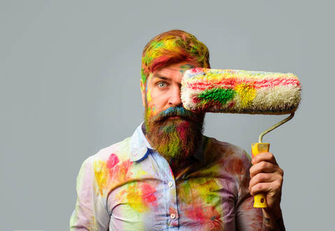 Painter man. Professional painter, decorator. Repair, building concept. Room painting job. Handsome bearded worker with paint ro