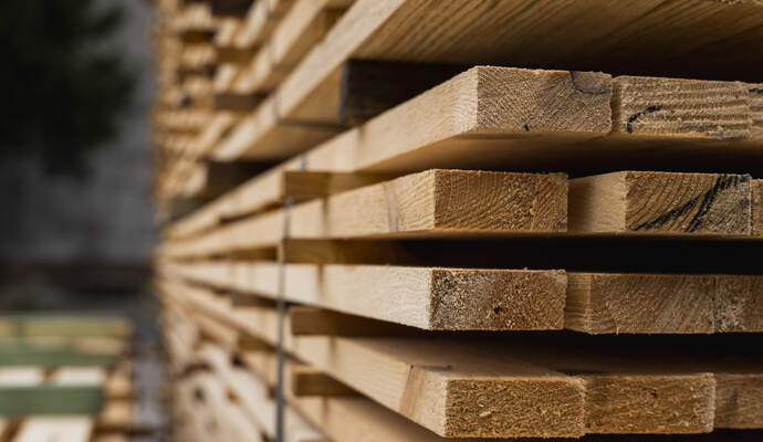 Piles of wooden boards in the sawmill, planking. Warehouse for sawing boards on a sawmill outdoors. Wood timber stack of wooden 